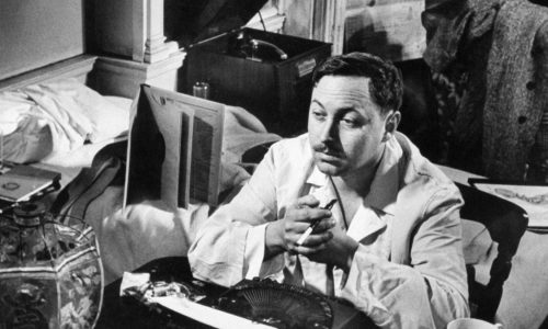 Playwright Tennesse Williams sitting at typewriter while working on a new play.